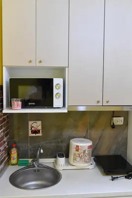 a kitchen counter with a sink and a microwave at Apartmani Ad fines in Kuršumlija