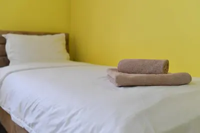 a bed with two towels sitting on top of it at Apartmani Ad fines in Kuršumlija