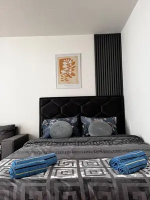 a bedroom with a large bed with blue pillows at Apartman RISTIC in Vranje