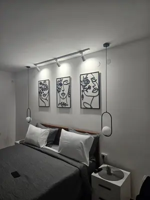 a bedroom with a bed with four pictures on the wall at Apartman Afrodita Lux 2 in Niš