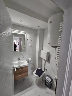 a bathroom with a toilet and a sink and a mirror at Apartman Afrodita Lux 2 in Niš