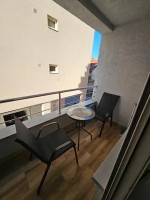 a balcony with two chairs and a table on a building at Apartman Afrodita Lux 2 in Niš