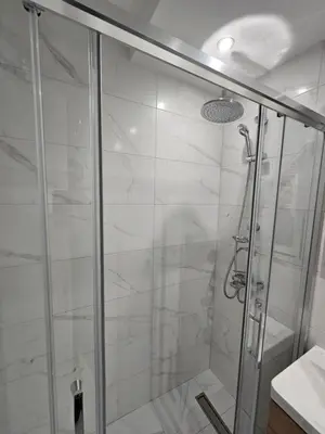 a bathroom with a shower with a glass door at Apartman Afrodita Lux 2 in Niš