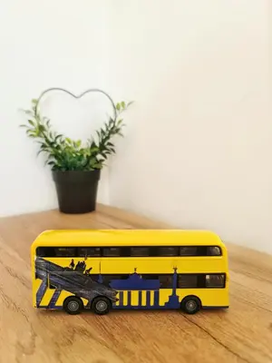 a yellow toy bus on a table with a plant at Apartman Berlin Sokobanja 2 in Soko Banja