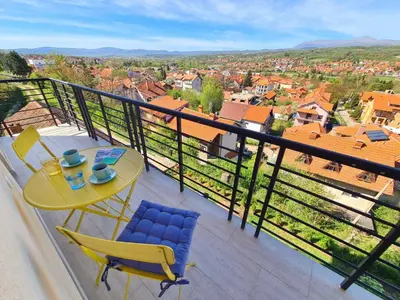 a balcony with a table and chairs and a view at Apartman Berlin Sokobanja 2 in Soko Banja