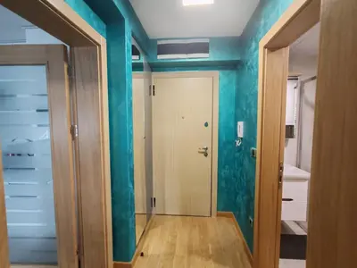 a room with blue walls and a hallway with a door at Apartmani Harizma in Vrnjačka Banja