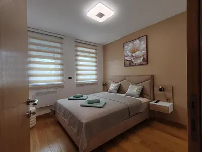 a bedroom with a bed with two pillows on it at Apartmani Harizma in Vrnjačka Banja