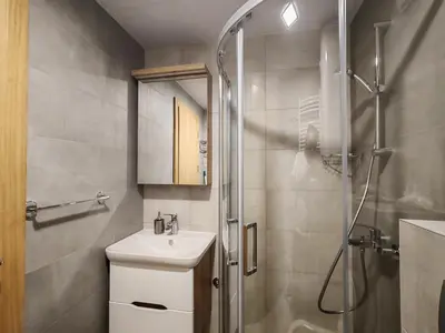 a bathroom with a shower and a toilet and a sink at Apartmani Harizma in Vrnjačka Banja