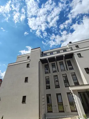 a white building with a blue sky in the background at Apartmani Harizma in Vrnjačka Banja