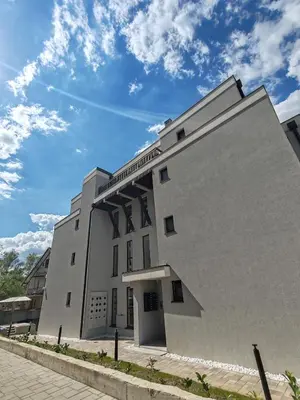 a white building with a sky in the background at Apartmani Harizma in Vrnjačka Banja