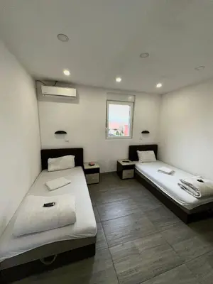 a room with two beds and a window at Apartmani Knez in Kruševac