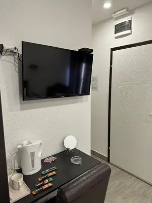 a room with a table and a tv on a wall at Apartmani Knez in Kruševac