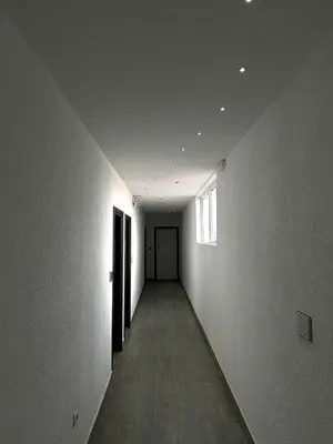 an empty hallway with white walls and a wooden floor at Apartmani Knez in Kruševac