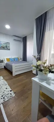 a bedroom with a bed and a table in a room at Apartman Mila 23 Vrnjačka Banja in Vrnjačka Banja