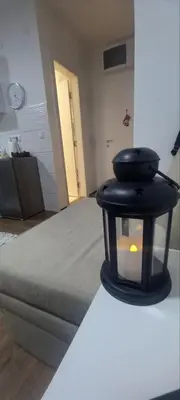 a candle sitting on top of a bed in a room at Apartman Mila 23 Vrnjačka Banja in Vrnjačka Banja
