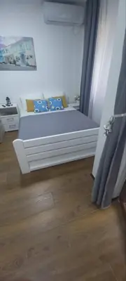 a bedroom with a bed with blue and yellow pillows at Apartman Mila 23 Vrnjačka Banja in Vrnjačka Banja