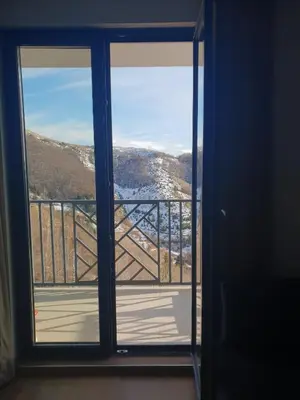 a room with a door open to a balcony with a view at Jigy Kop in Kopaonik