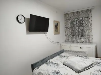 a bedroom with a bed and a tv on the wall at Apartman NINASTA in Pirot