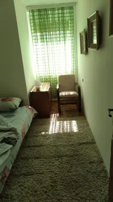 a bedroom with a bed and a chair and a window at Apartman NINASTA in Pirot