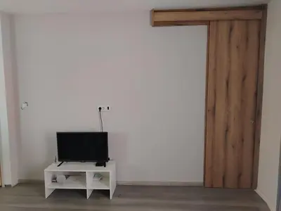 a tv sitting on a stand next to a white wall at Passage in Paraćin