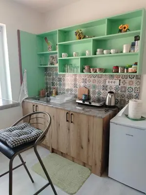 a kitchen with green shelves and a chair and a sink at Passage in Paraćin