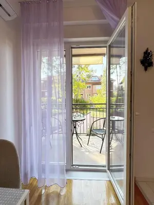 a sliding glass door to a balcony with a table at Studio GAGI in Vrnjačka Banja