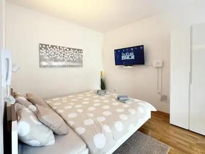 a bedroom with a bed and a tv on the wall at Studio GAGI in Vrnjačka Banja