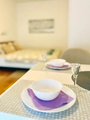 a white bowl on a plate on a table at Studio GAGI in Vrnjačka Banja