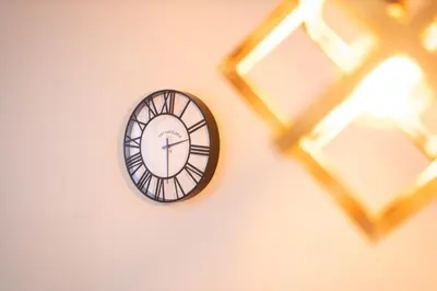 a clock on a wall next to a window at Studio Iris 2 in Niš