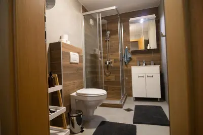 a bathroom with a toilet and a glass shower at Studio Iris 2 in Niš