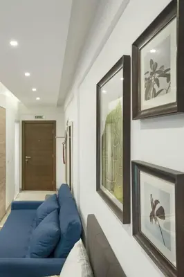 a living room with a blue couch and framed pictures at Studio Ristic Milmari L5 in Kopaonik