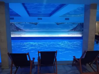 two chairs in front of a swimming pool at night at Studio Ristic Milmari L5 in Kopaonik