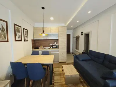 a living room with a blue couch and a table at Studio Ristic Milmari L5 in Kopaonik