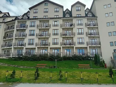 a large white building with benches in front of it at Studio Ristic Milmari L5 in Kopaonik