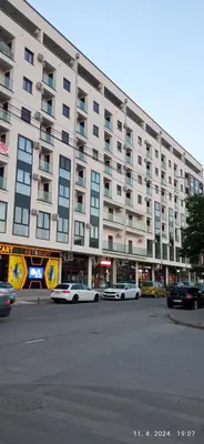 a large building with cars parked in front of it at Emili lux in Jagodina