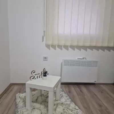 a white room with a table and a radiator at Emili lux in Jagodina