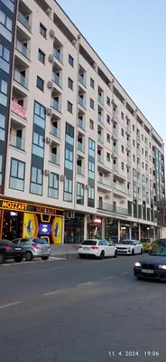 a large building with cars parked in front of it at Emili lux in Jagodina
