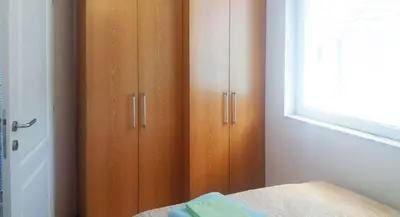 a bedroom with wooden cabinets and a window at Apartman Pazova in Soko Banja