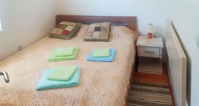 a bedroom with a bed with green towels on it at Apartman Pazova in Soko Banja