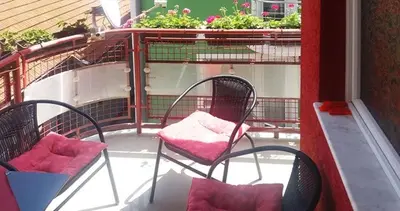 a balcony with two chairs and a bird cage at Apartman Pazova in Soko Banja