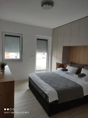 a bedroom with a large bed and a large window at Central Lux ( U CENTRU GRADA, 30m od SPA centra) in Soko Banja