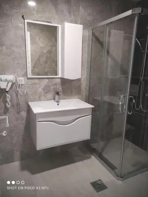 a bathroom with a white sink and a shower at Central Lux ( U CENTRU GRADA, 30m od SPA centra) in Soko Banja