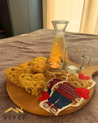 a wooden plate with food and a glass of juice at Apartmani Viver Vrnjačka Banja in Vrnjci