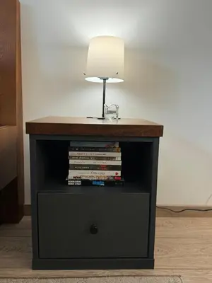 a table with a lamp and a stack of books at Apartmani Viver Vrnjačka Banja in Vrnjci
