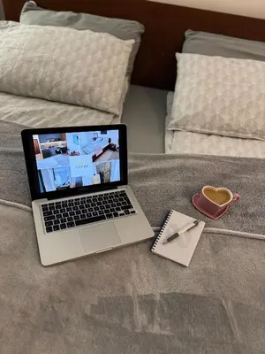 a laptop computer sitting on a bed with a cup of coffee at Apartmani Viver Vrnjačka Banja in Vrnjci