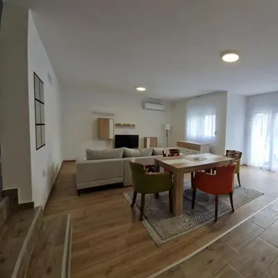 a living room with a table and chairs and a couch at Apartman Milos - centar grada free parking in Vranje
