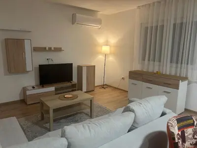 a living room with a couch and a tv at Apartman Milos - centar grada free parking in Vranje