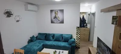 a living room with a blue leather couch at Apartman VRH in Vrnjačka Banja