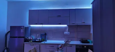 a kitchen with white cabinets and a blue light at Apartman VRH in Vrnjačka Banja