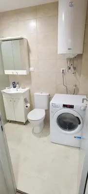 a bathroom with a washing machine and a toilet at Apartman VRH in Vrnjačka Banja